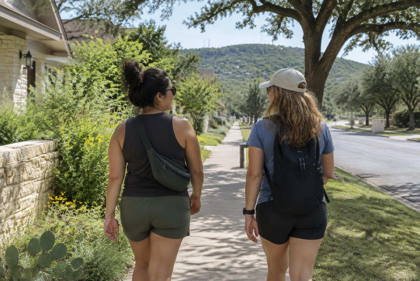 Two friends walking together through a Texas neighborhood